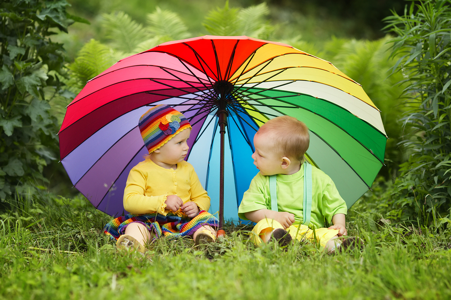 little children under colorful umbrella